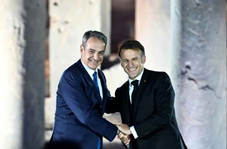 Le Premier ministre grec Kyriakos Mitsotakis (g) et le président français Emmanuel Macron à l'issue d'un événement à l'Agora romaine d'Athènes, le 24 avril 2026 en Grèce
