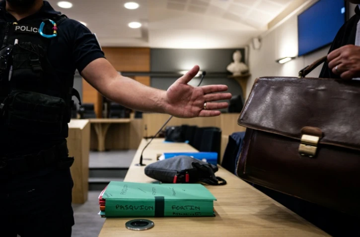 Un policier à côté de dossiers le 13 juin 2023 dans la salle de la cour d'assises de la Drôme, à Valence, où se tient le procès de Gabriel Fortin