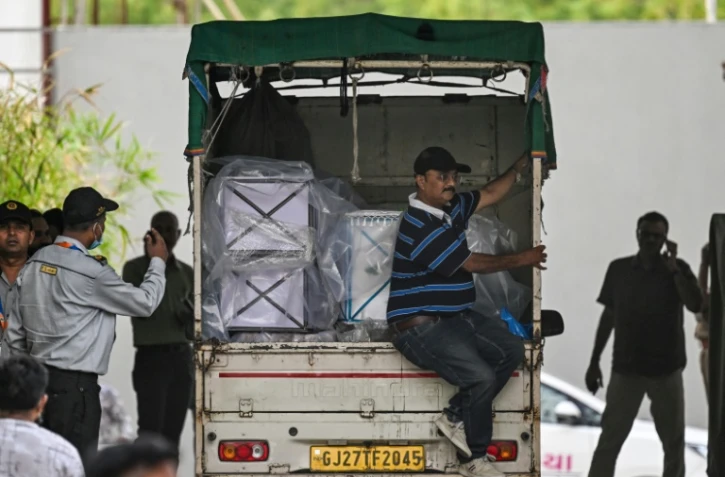 Un camion chargé de cercueils de victimes arrive à la morgue du complexe hospitalier d'Ahmedabad, le 14 juin 2025, après le crash du vol 171 d'Air India dans un quartier résidentiel près de l'aéroport le 12 juin 2025