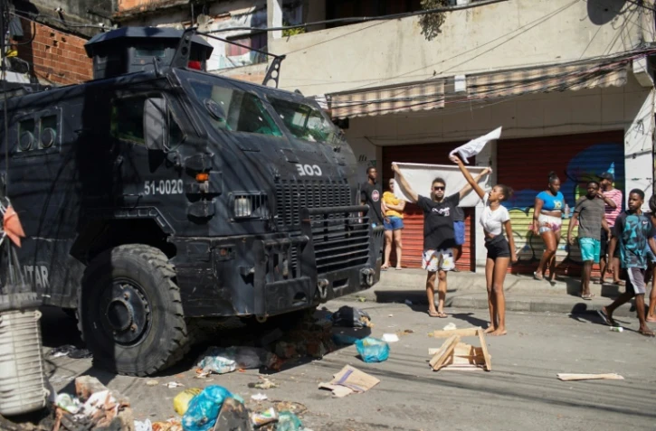 Un véhicule blindé des forces de l'ordre face à des habitants lors d'une opération policière dans la favela Complexo do Alemao à Rio de Janeiro, le 21 juillet 2022