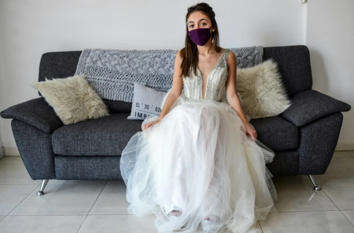 L'Argentine Mia Minutillo, masquée, dans sa robe de "quinceanera", chez elle à Buenos Aires, le 30 juillet 2020