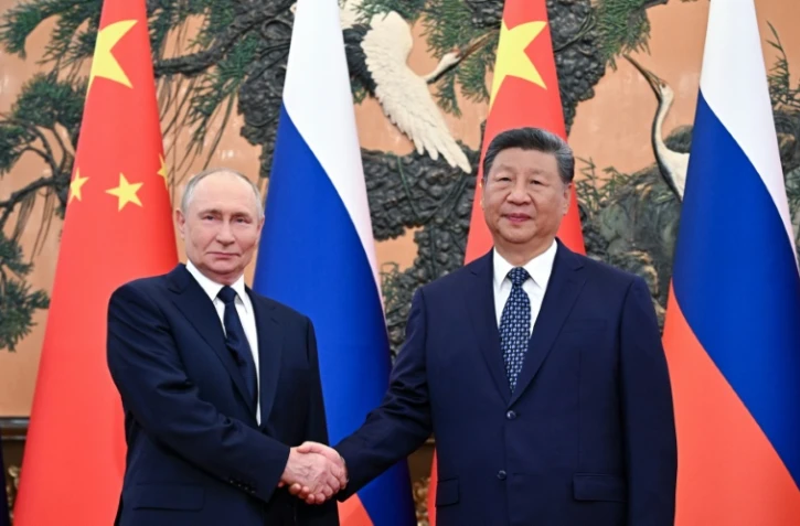Photo diffusée par l'agence de presse russe Sputnik montrant le président russe Vladimir Poutine (g) et le président chinois Xi Jinping lors d'une rencontre au Palais de l'Assemblée du Peuple à Pékin, le 2 septembre 2025