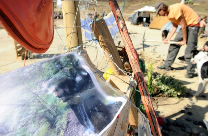 Un homme plante un arbre le 29 octobre 2014, sur le site occupé du barrage de Sivens (Tarn), à côté d'un mémorial à la mémoire de Rémi Fraisse, un manifestant qui y est décédé le 26 octobre lors d'un violent affrontement avec la police