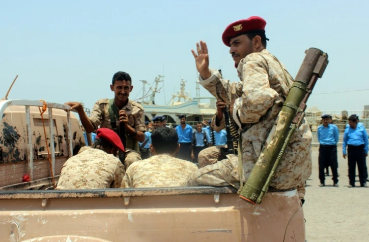Un rebelle Houthi fait un signe de la main lors du retrait annoncé de troupes rebelles du port de Salif, au Yémen, le 11 mai 2019