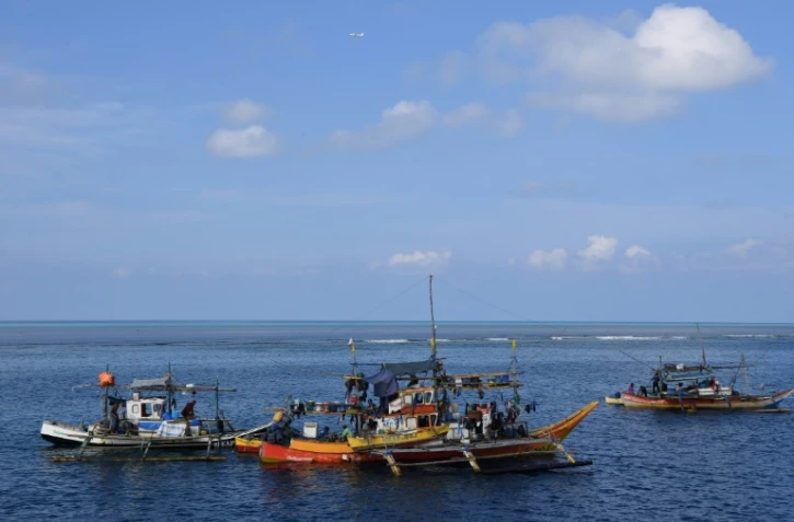 Des bateaux de pêcheurs philippins ancrés près du récif de Scarborough, le 21 septembre 2023 dans les eaux disputées en mer de Chine