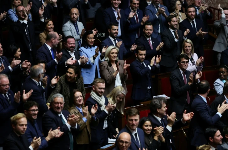 La présidente du groupe Rassemblement national à l'Assemblée nationale, Marine Le Pen, applaudit avec d'autres membres du RN durant l'examen des textes de ce parti le 30 octobre 2025 à Paris