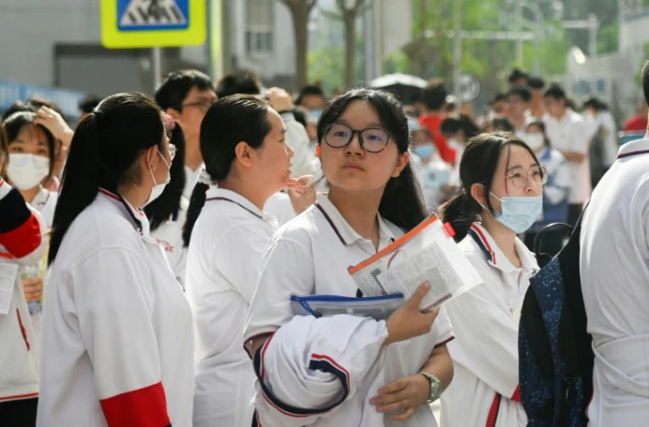 Des étudiantes devant une école au premier jour du gaokao, l'examen national d'entrée à l'université, le 7 juin 2023 à Pékin