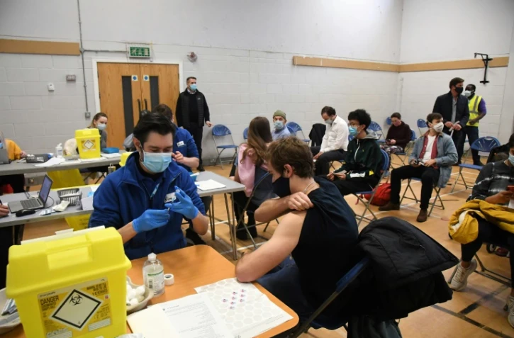 Des personnes se font vacciner contre le Covid-19, le 13 décembre 2021 à Londres