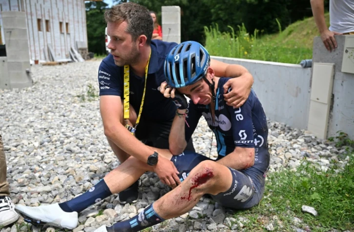 Le cycliste français de l'équipe DSM - Firmenich Romain Bardet avec un membre de son staff après une chute conduisant à son abandon lors de la 14e étape du Tour de France entre Annemasse et Morzine Les Portes du Soleil, dans les Alpes le 15 juillet 2023