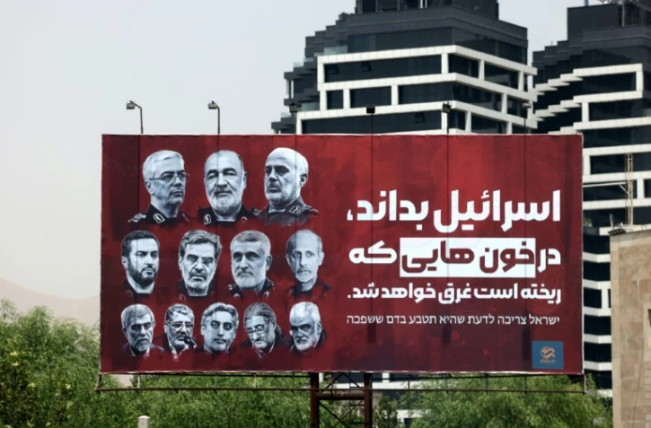 Les portraits de hauts gradés tués dans les attaques israéliennes sont affichés dans une rue de Téhéran, avec le slogan en farsi: "Israël doit savoir qu'il se noiera dans le sang qu'il a fait couler", le 26 juin 2025