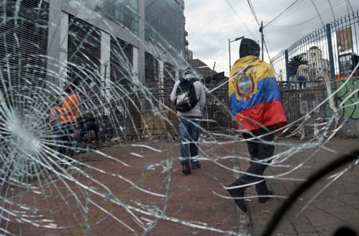 Un manifestant indigène enveloppé d'un drapeau équatorien près d'une barricade au voisinage de l'Assemblée nationale, à Quito le 26 juin 2022