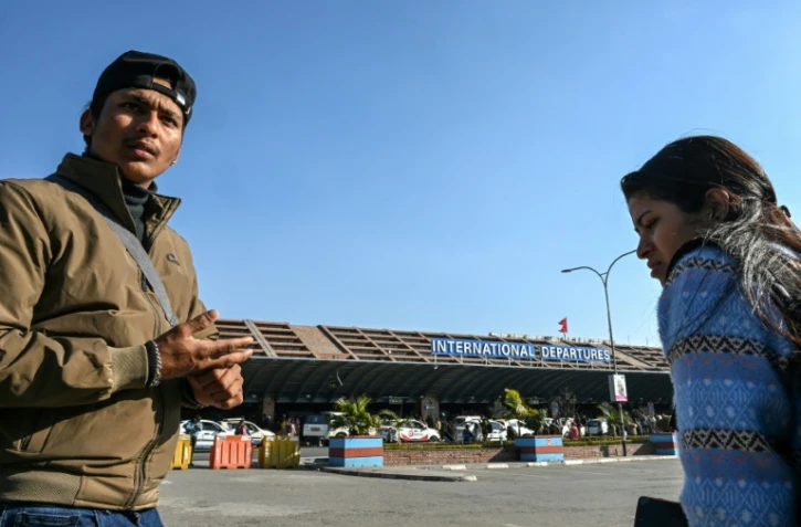 Lalit Bishowkarma (g) attend à l'aéroport international de Katmandou de récupérer la dépouille de son père Rudra Bahadur Kami, mort en Arabie saoudite où il était parti travailler, le 21 janvier 2026 au Népal