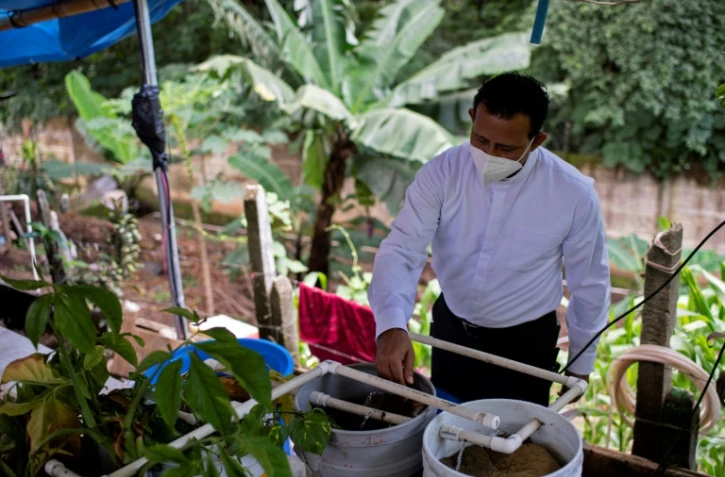 Moises Rutilio Moran, curé à Santa Ana, à une soixantaine de kilomètres au nord-ouest de la capitale San Salvador, dans sa pisciculture, le 19 août 2020