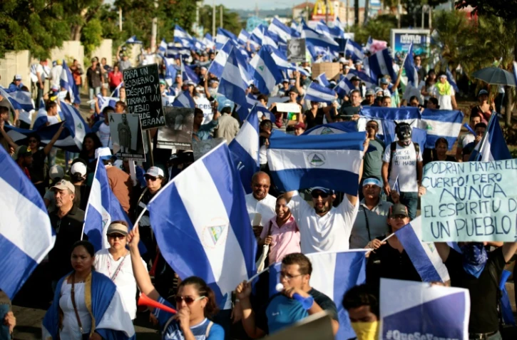 Des participants à une marche commémorant le début des manifestations contre le gouvernement nicaraguayen, il y a un mois, le 18 mai 2018 à Managua