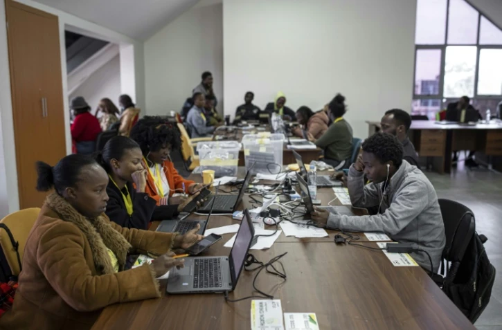 Des employés de l'United Democratic Alliance (UDA) recomptent et vérifient les votes à partir du site de la commission électorale indépendante (IEBC), le 11 août 2022à Nairobi, au Kenya