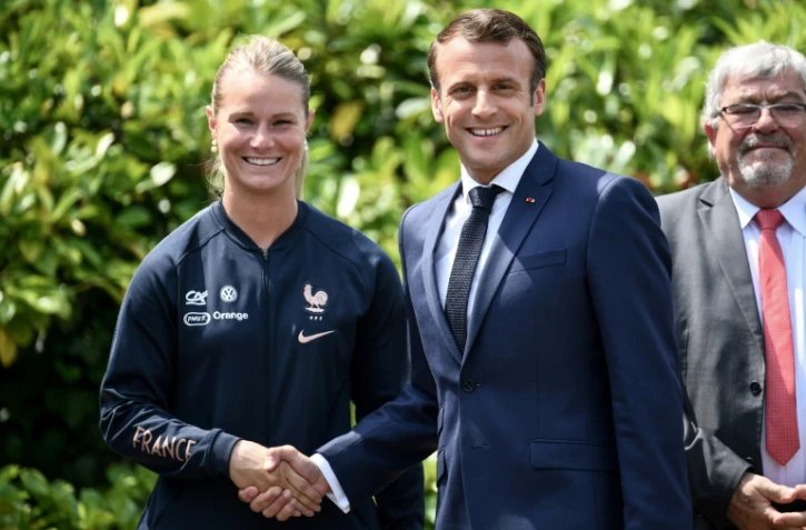 La capitaine des Bleues Amandine Henry serre la main du président Emmanuel Macron en visite au centre d'entraînement de Clairefontaine, le 4 juin 2019