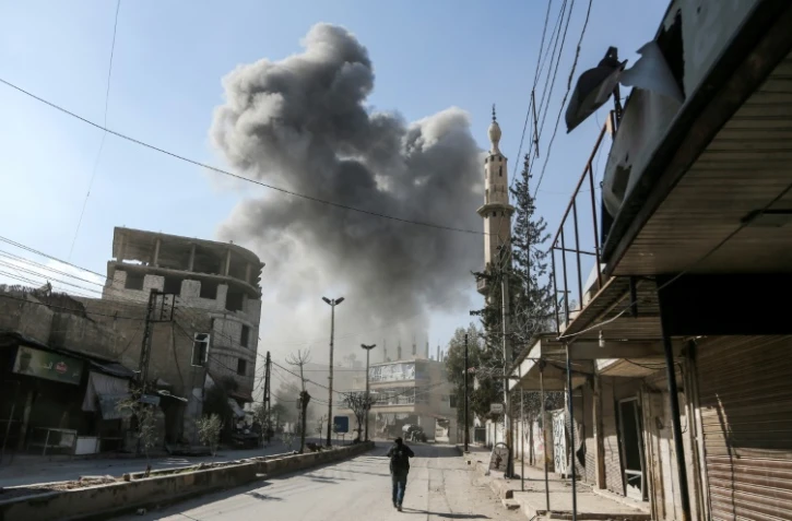 De la fumée s'élève au-dessus d'un bâtiment après des bombardements sur la ville de Hamouria, dans l'enclave rebelle de la Ghouta orientale, près de Damas le 21 février 2018