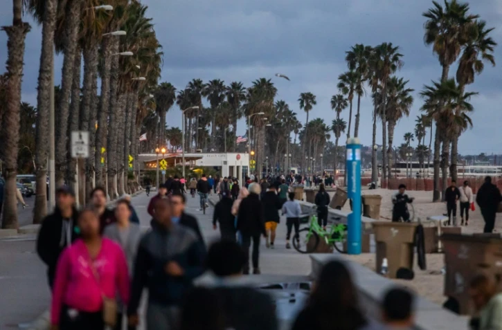 Des promeneurs le long de la plage à Santa Monica, le 19 mars 2020, 20 minutes après l'annonce du confinement par le gouverneur de Californie