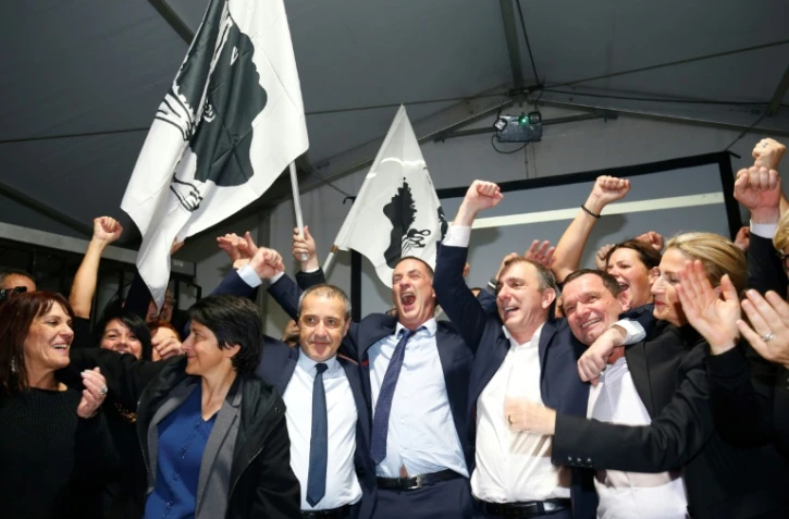 Les candidats pour le parti nationaliste corse Pe a Corsica Jean Guy Talamoni (4eG) et Gilles Simeoni (5eD) célèbrent leur triomphe électoral le 10 décembre 2017