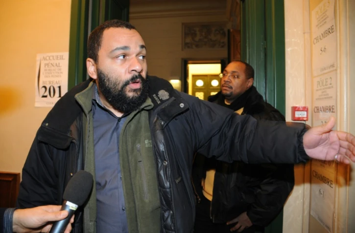 L'humoriste Dieudonné M'bala M'bala répond aux journalistes à son arrivée au palais de justice de Paris le 3 février 2011