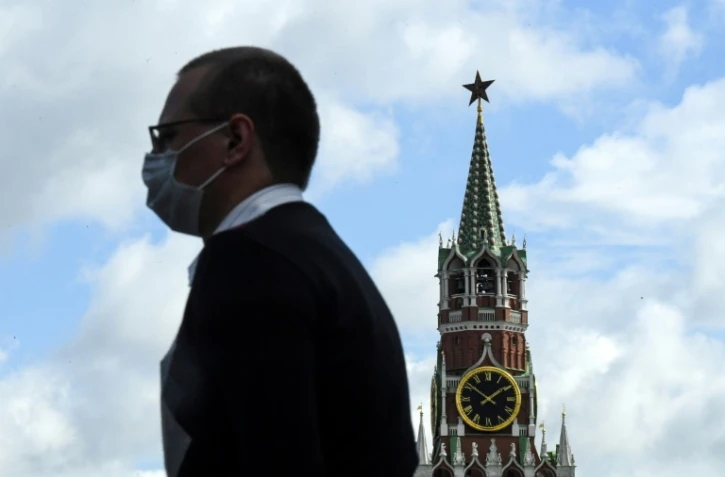 Un homme portant un masque passe devant le Kremlin, à Moscou, le 12 août 2020