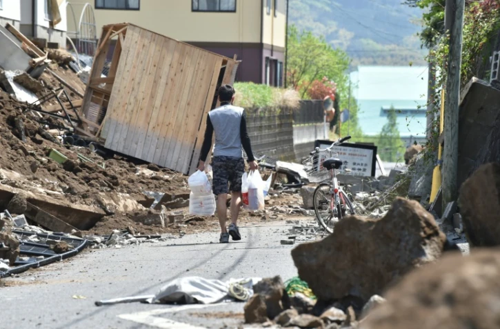 Un homme marche dans les rues de Mashiki, dans la préfecture de Kumamoto dans le sud-ouest du Japon, frappée par un séisme le 15 avril 2016