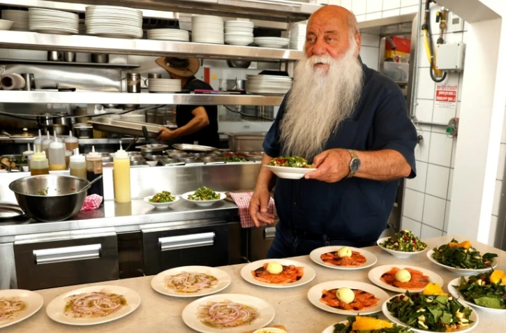 Le cuisinier israélien Uri Jeremias devant une sélection de plats dans son restaurant à Acre, le 2 mai 2022
