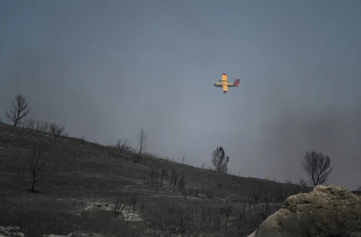 Un Canadair survole une zone dévastée par le feu près de Graveson, au sud d'Avignon, dans le massif de la Montagnette, le 15 juillet 2022 