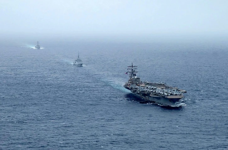 Une photo publiée avec l'autorisation du compte Twitter de l'US Navy le 25 juillet 2021 montre le porte-avions USS Ronald Reagan, la frégate française FS Languedoc et le destroyer USS Halsey en mer d'Oman