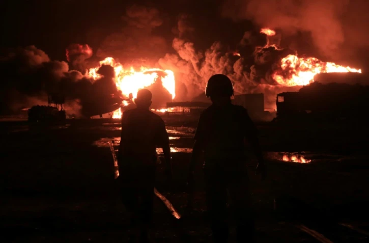 Les pompiers arrivent sur les lieux d'un incendie énorme dans une installation de stockage de carburant au port de Hodeida au Yémen, à la suite des frappes israéliennes, le 20 juillet 2024