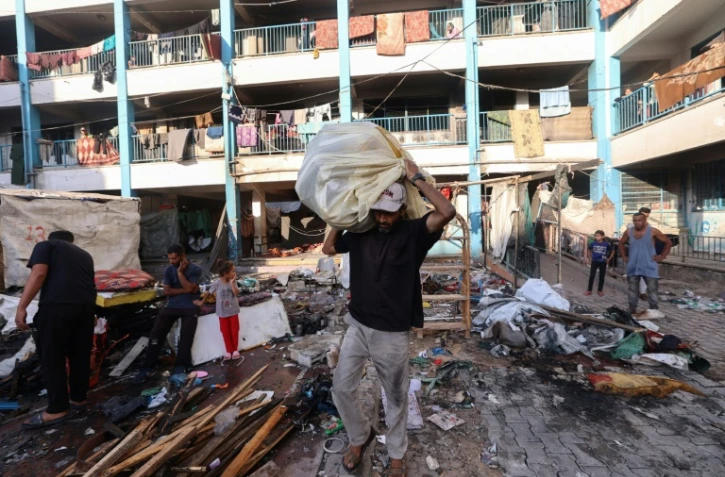 Des Palestiniens dans les décombres après une frappe israélienne sur une école abritant des  personnes déplacées à Al-Bureij, dans le centre de la bande de Gaza, le 8 juillet 2025