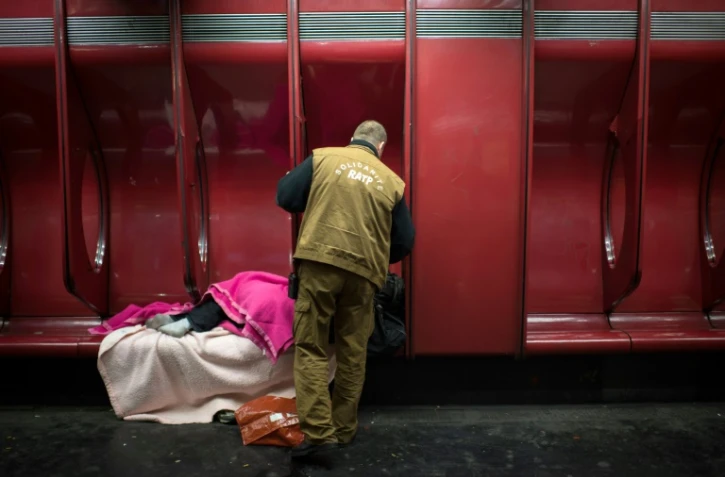 Un travailleur social de la RATP parle à un SDF dans une station de métro à Paris, le 27 mars 2013