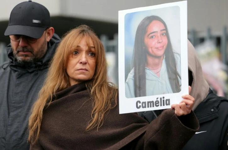 La mère de Camélia, une lycéenne qui s'est suicidée le 13 janvier, brandit le portrait de sa fille lors d'une marche en sa mémoire, le 25 janvier 2026 à Mitry-Mory, en région parisienne