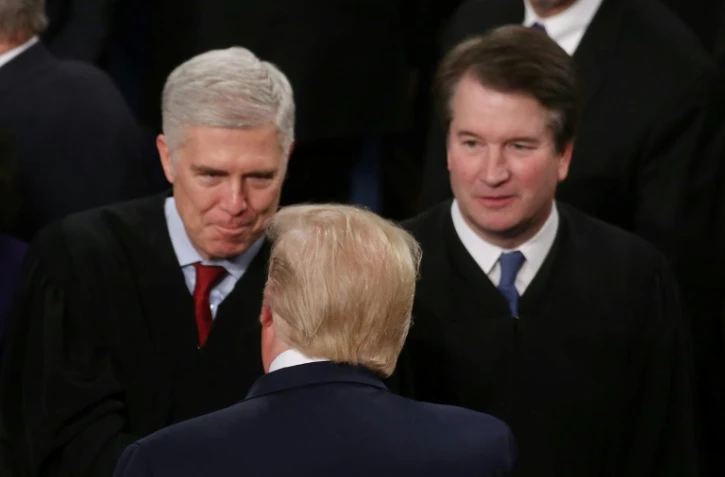 Le président américain Donald Trump salue les juges Neil Gorsuch et Brett Kavanaugh, qu'il a fait entrer à la Cour suprême des Etats-Unis, à Washington le 4 février 2020