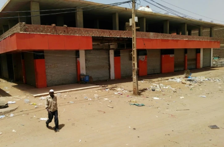 Un Soudanais marche devant des magasins fermés dans une rue déserte de la capitale Khartoum, le 10 juin 2019