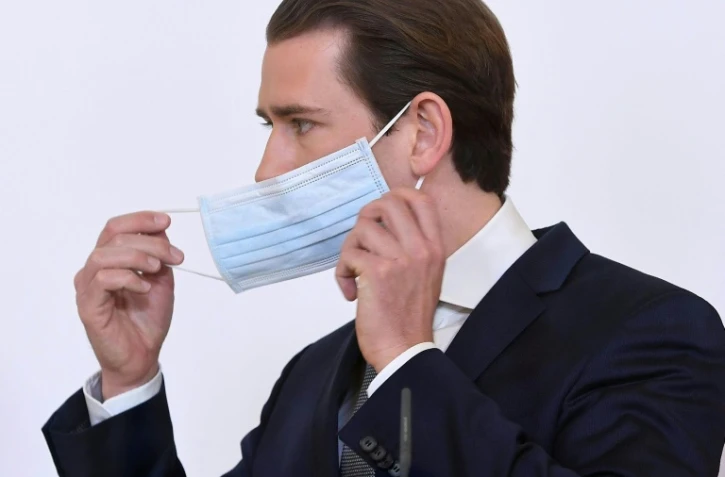 Le chancelier autrichien Sebastian Kurz retire son masque de protection lors pour une conférence de presse le 6 avril 2020