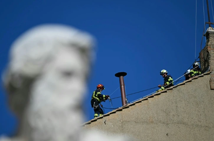 Des pompiers installent la cheminée sur le toit de la chapelle Sixtine le 2 mai 2025
