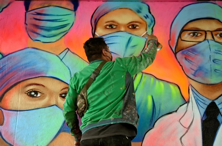 L'artiste mexicain Sergio Morelos, plus connu sous le nom Applezman, peint une fresque en hommage au personnel soignant, à Mexico le 25 août 2020