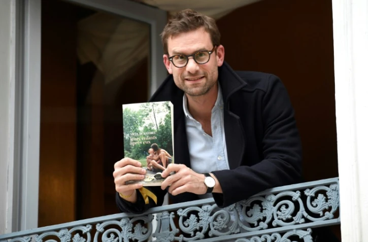 Nicolas Mathieu pose avec son livre "Leurs enfants après eux" après avoir remporté le Prix Goncourt, le 7 novembre 2018 à Paris
