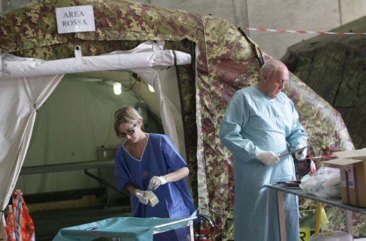 Des experts italiens travaillent à l'identification de migrants dans une tente réfrigérée le 5 novembre 2015 à Melilli, en Sicile