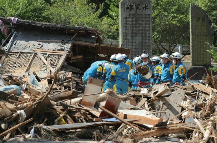 Des équipes de secouristes recherchent des survivants, le 13 juillet 2018 à Sakacho, au Japon