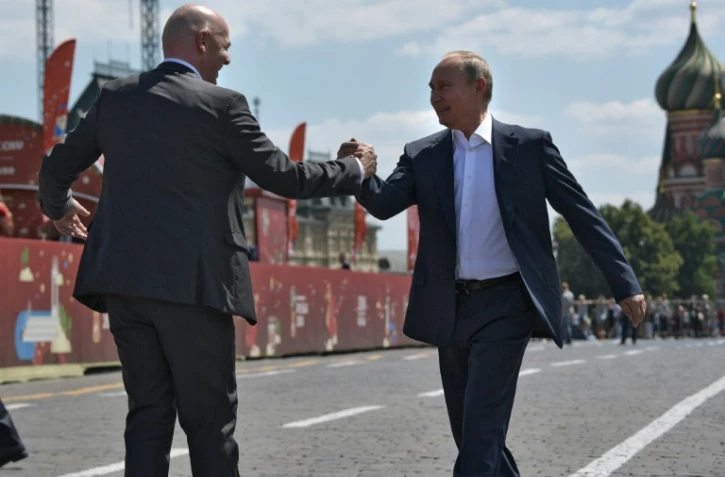 Le président de la Fifa Gianni Infantino (g) serre la main du président russe Vladimir Poutine, le 28 juin 2018 à Moscou 