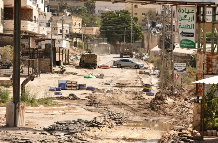 Des véhicules blindés de l'armée israélienne roulent sur une route lors d'un raid dans le camp de réfugiés palestiniens d'al-Faraa, près de la ville de Toubas, en Cisjordanie occupée, le 28 août 2024