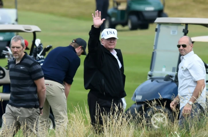 Le président américain Donald Trump (c) sur le parcours de golf de son luxueux complexe hôtelier de Turnberry, le 14 juillet 2018 en Ecosse