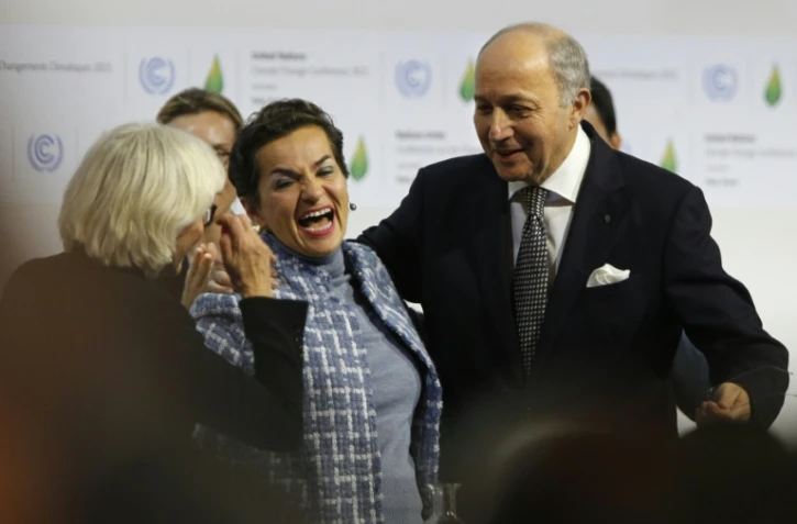 Laurence Tubiana (g), Christiana Figueres et Laurent Fabius célèbrent l'adoption de l'accord sur le climat, au Bourget, le 12 décembre 2015