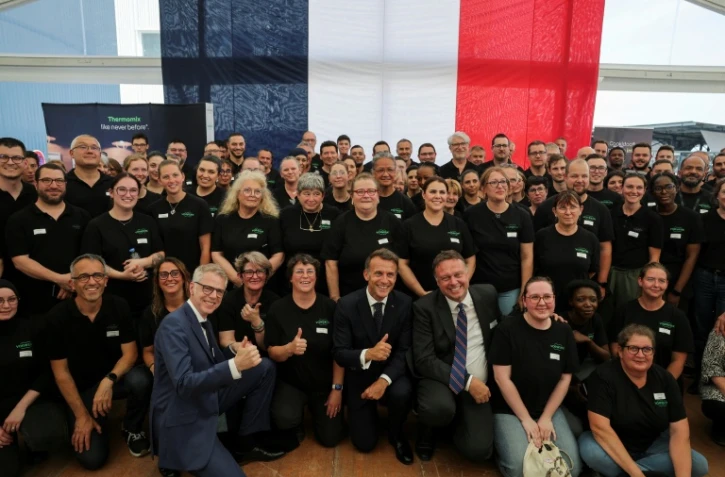 Le président français Emmanuel Macron pose avec les employers de l'usine Vorwerk, qui produit les appareils Thermomix, dans le cadre des "Choose France Days", à Donnemain-Saint-Mamès (Eure-et-Loir), le 29 mai 2026