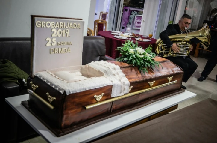 Un musicien joue à côté d'un gâteau en forme de cercueil au "bal des croque-morts", le 2 novembre 2019 à Pozarevac, en Serbie