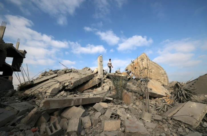 Un Palestinien au sommet des décombres d'un bâtiment touché par une frappe israélienne dans le camp de réfugiés de Bureij, dans le centre de la bande de Gaza, le 10 juillet 2025