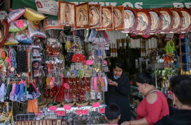 Une femme vend des images religieuses près de la basilique de Guadalupe, à Mexico le 20 mars 2020