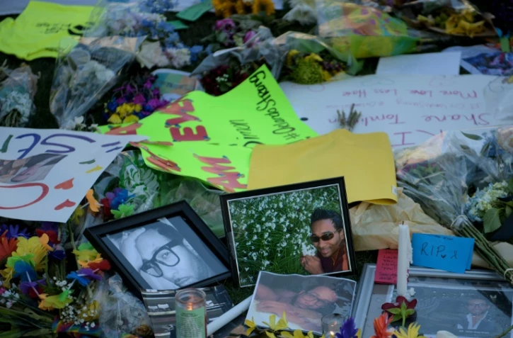 Des photos et des fleurs dispersés devant le mémorial pour les victimes du Pulse à Orlando le 14 juin 2016